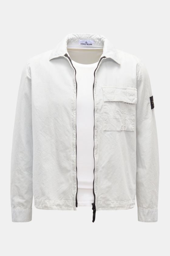 Stone Island Overshirt 'Brushed Canvas' pastellblau, Frontansicht, Slim Fit mit Umlegekragen, Zwei-Wege-Reißverschluss, Brusttasche, Knopfärmeln und Kompass-Badge. Stone Island Overshirt 'Brushed Canvas' pastellblau, Frontansicht, Slim Fit mit Umlegekragen, Zwei-Wege-Reißverschluss, Brusttasche, Knopfärmeln und Kompass-Badge.