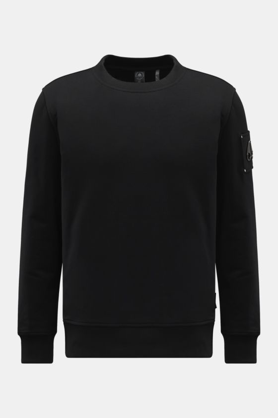 Moose Knuckles Sweatshirt 'Hartsfield Crew' schwarz, frontal fotografiert, aus reiner Baumwolle mit Metall-Logo-Patch am Oberarm, Rundhals, Rippbündchen. Moose Knuckles Sweatshirt 'Hartsfield Crew' schwarz, frontal fotografiert, aus reiner Baumwolle mit Metall-Logo-Patch am Oberarm, Rundhals, Rippbündchen.