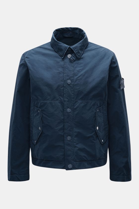 Stone Island Jacke 'Ghost Piece' dunkelblau, Slim Fit, Microfaser, Druckknopfleiste, Umlegekragen, Fronttaschen, Kompass-Badge am Oberarm, Ärmelsaum mit Knopf, frontal fotografiert. Stone Island Jacke 'Ghost Piece' dunkelblau, Slim Fit, Microfaser, Druckknopfleiste, Umlegekragen, Fronttaschen, Kompass-Badge am Oberarm, Ärmelsaum mit Knopf, frontal fotografiert.