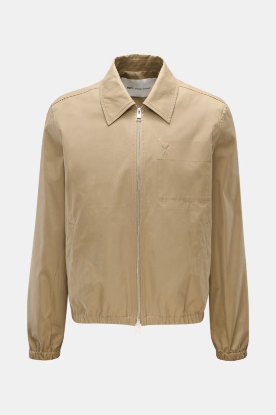 Frontale Ansicht des Ami Paris Blouson taupe aus reiner Baumwolle mit Umlegekragen, Zwei-Wege-Reißverschluss, Logo-Stitching, schräge Leistentaschen, elastischen Saum- und Ärmelbündchen im Slim Fit. Frontale Ansicht des Ami Paris Blouson taupe aus reiner Baumwolle mit Umlegekragen, Zwei-Wege-Reißverschluss, Logo-Stitching, schräge Leistentaschen, elastischen Saum- und Ärmelbündchen im Slim Fit.