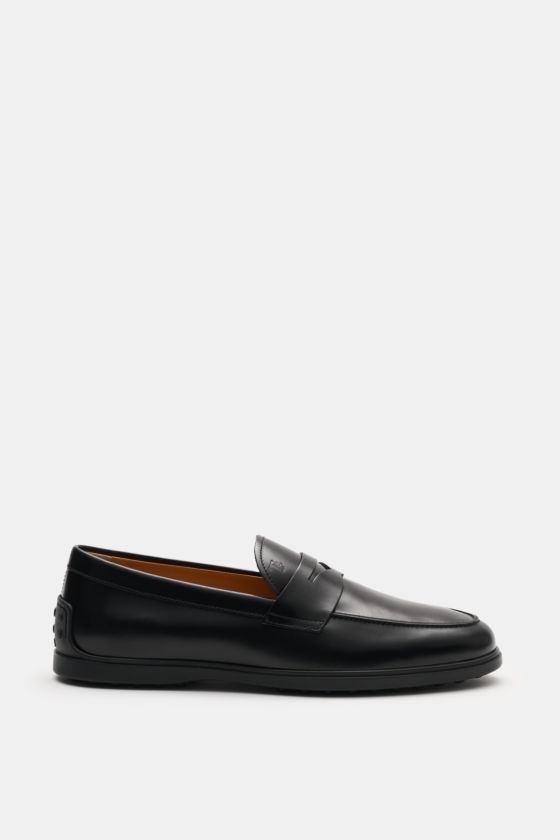Seitliche Ansicht eines Tod's Penny Loafer schwarz aus edlem Glattleder, leicht schmal zulaufend, mit typischem Penny Strap, Steppnaht auf der Vorderkappe, Noppendetail an der Ferse, Gummilaufsohle mit Noppen, made in Italy. Seitliche Ansicht eines Tod's Penny Loafer schwarz aus edlem Glattleder, leicht schmal zulaufend, mit typischem Penny Strap, Steppnaht auf der Vorderkappe, Noppendetail an der Ferse, Gummilaufsohle mit Noppen, made in Italy.