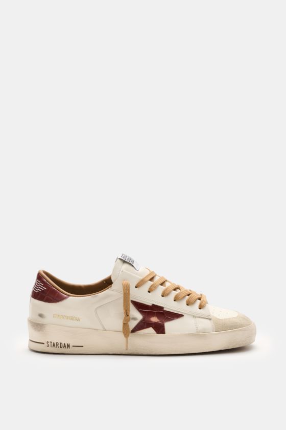 Golden Goose Sneaker 'Stardan' offwhite/bordeaux seitlich fotografiert mit Vintage-Finish, Stern, Used-Optik, Nappaleder, Velours-Overlays, Gummisohle. Golden Goose Sneaker 'Stardan' offwhite/bordeaux seitlich fotografiert mit Vintage-Finish, Stern, Used-Optik, Nappaleder, Velours-Overlays, Gummisohle.