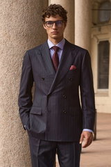 Front view of a model wearing a navy striped double-breasted suit from Cesare Attolini, light blue 'Nando' shark collar shirt from Borrelli, burgundy and blue 'Ventaglio' tie from Cesare Attolini, dark red and grey silk pocket square from Brunello Cucinel