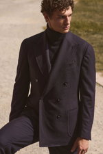 Front angled view of a male model wearing a navy melange double-breasted suit named 'Andrea' from Stile Latino with a navy cashmere turtleneck sweater from Aida Barni, featuring refined tailoring and luxurious textures in a deep navy color palette, captur