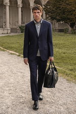 Shop by Look 12 Edition Vol. 19 front view of a model dressed in a navy striped Canali suit 'Giacca', grey cashmere polo by Fioroni, navy violet Brunello Cucinelli pocket square, black Church's 'Pembrey' loafers, carrying a black Serapian shopper bag, wal