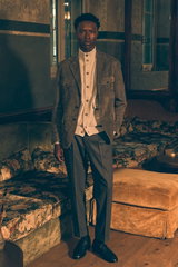 Front view of a model wearing a dark grey suede blazer from Rifugio over a light grey melange cashmere cardigan from Fioroni, paired with dark grey melange wool trousers in a 'Rebel Fit' from PT Torino and black 'Royal' penny loafers from Henderson, blend