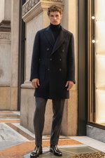 Front view of a model wearing a navy short coat from Mandelli over a navy fine knit turtleneck sweater from FTC, paired with grey melange jogpants 'Chiaia' from Marco Pescarolo and black leather shoes. The sophisticated and elegant look combines tailored 