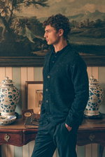 Side profile of a male model wearing a navy melange Drumohr cardigan over a dark blue Fioroni cashmere polo, paired with navy Marco Pescarolo wool jogpants, blending rich textures and deep blue tones for a sophisticated yet comfortable look in Shop by Loo