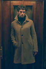 Front view of a male model wearing a light brown cashmere short coat from Lunaria Cashmere with high collar and button closure, dark brown cashmere turtleneck sweater from FTC underneath, showcasing a sophisticated warm look in earthy tones, Shop by Look 