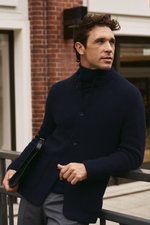 Shop by Look 03 Denis Cebulec in Lardini for BRAUN Hamburg, seitliche Nahaufnahme, trägt navy Cardigan Lardini, Feinstrick-Rollkragenpullover FTC, graue Wollhose PT Torino, hält schwarze Dokumentenmappe Tom Ford, stilvoller Business-Casual Look.