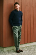 Shop by Look 04 HW 2026 shows a front-facing model wearing a navy cable-knit sweater over a green/navy plaid shirt, light green corduroy pants with colorful bird embroidery, and dark brown leather tassel loafers, combining classic textures and patterns wi