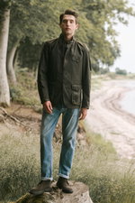 Shop by Look 19 HW 2026, Mann frontal stehend mit dunkelblauem Dondup Jeanshemd, rauchblauer Dondup Jeans 'Bray' und Officine Creative Schnürboots.