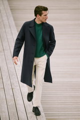 Mann in seitlicher Nahaufnahme mit navyblauem Wollmantel von Harris Wharf London, grünem Cashmere-Seide Pullover 'Felton' von Iris von Arnim und sandfarbener Cordhose 'Clifton' von Closed, Teil des Shop by Look 23 HW 2026, elegantes und gemütliches Outfit