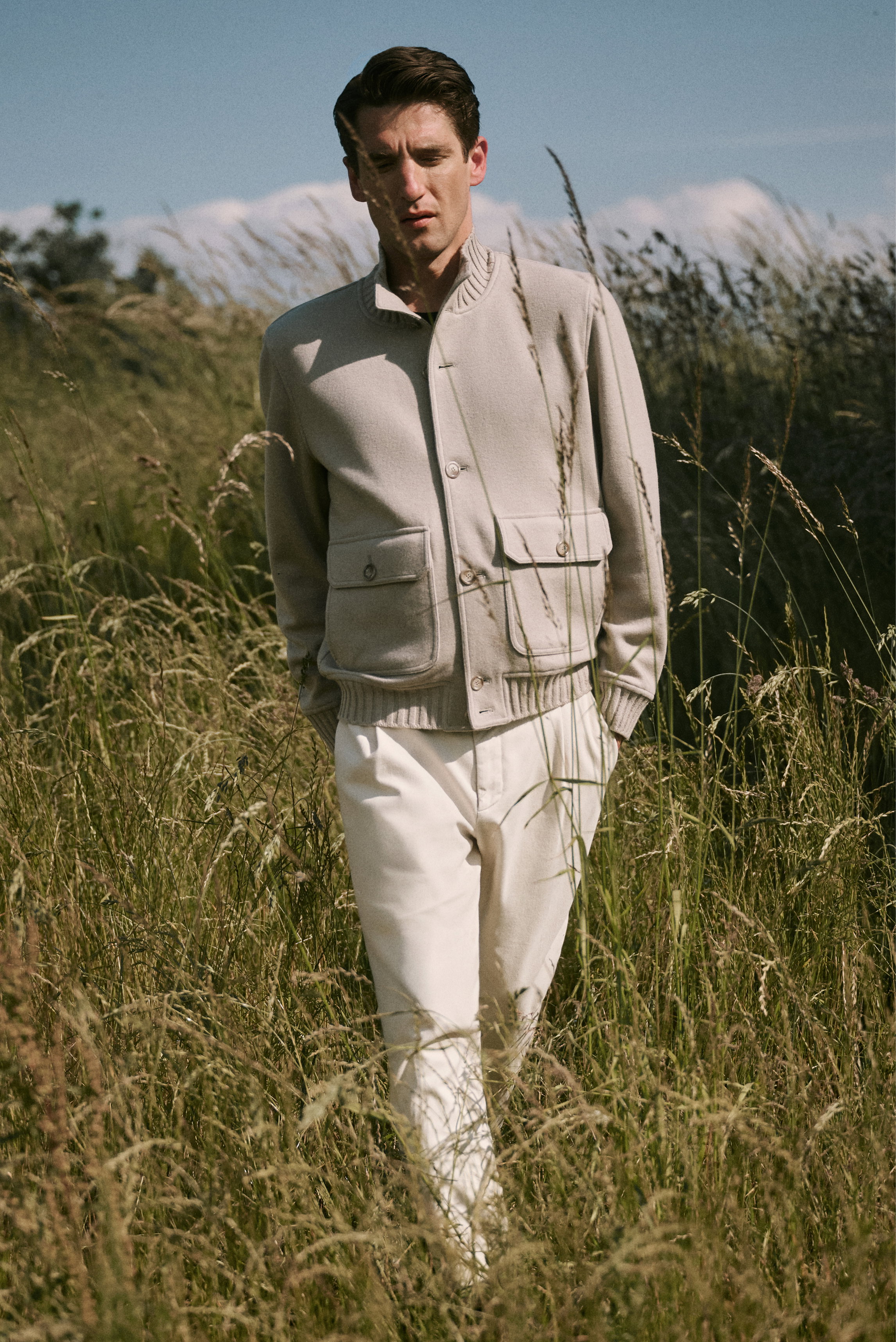 Mann frontal in Natur, trägt beigen Cashmere-Blouson 'Surreale' von Fedeli, dunkelvioletten Merino-Pullover B.F. Knitwear, helle Hose, braune Officine Creative Boots, Shop by Look 35 HW 2026, elegant-lässig für kühle Tage.