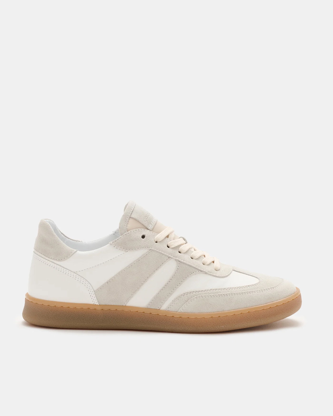 Beiger Sneaker aus Wildleder und Leder mit weißen Details, brauner Gummisohle, Schnürung und seitlichen Applikationen.